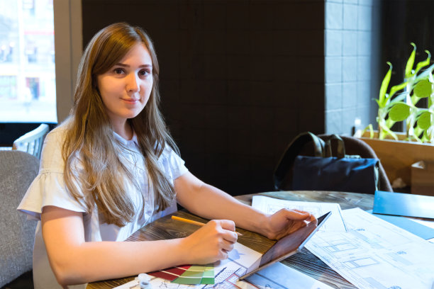 女孩正在用平板电脑和艺术家工具进行室内项目图片下载