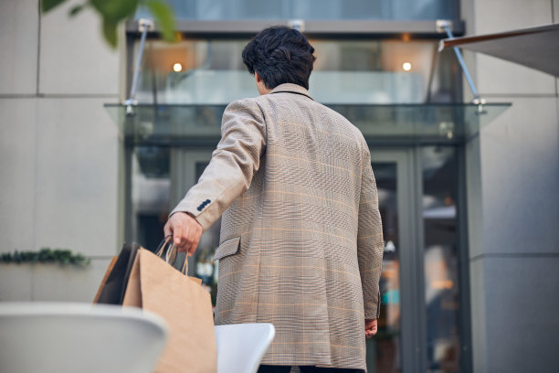 时尚的年轻人拿着购物袋在街上图片下载