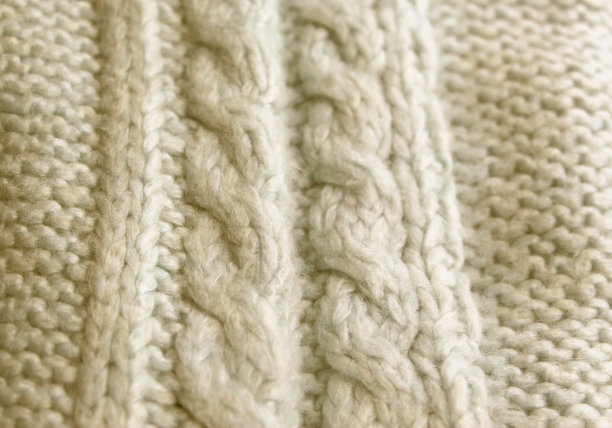 编织图案的辫子，辫子和简单的模式。棉或羊毛制成的天然纱线。蓝色刺绣背景。图片下载