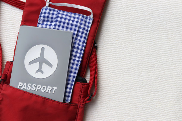 俯视图的护照旅行和布面罩在红色的肩袋与副本空间上的白色背景。图片下载