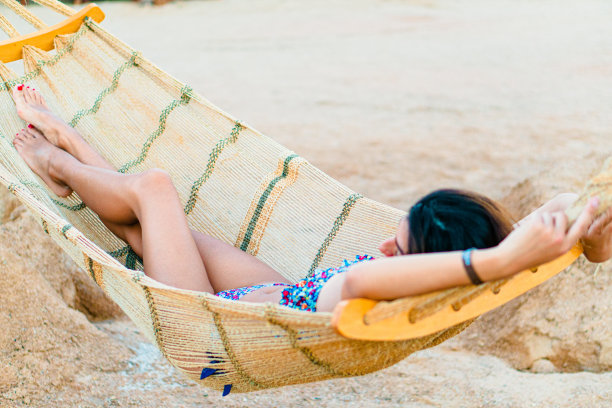 在度假期间，美丽女孩在美丽的度假村的吊床上放松身心图片下载