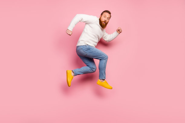 全尺寸侧面照片惊讶的家伙跳令人难以置信的折扣印象深刻，跑得快，穿毛衣鞋孤立在柔和的颜色背景图片下载