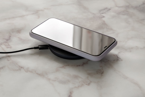 卧室衣柜里的白色智能手机，通过无线充电器充电图片下载