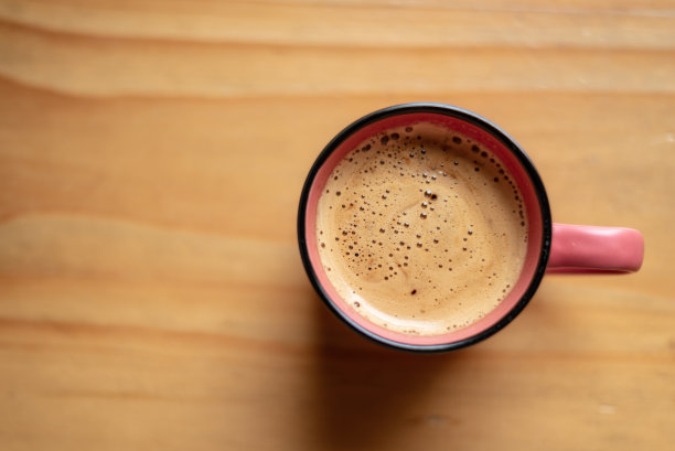 木桌上放着刚煮好的咖啡的粉色杯子图片下载