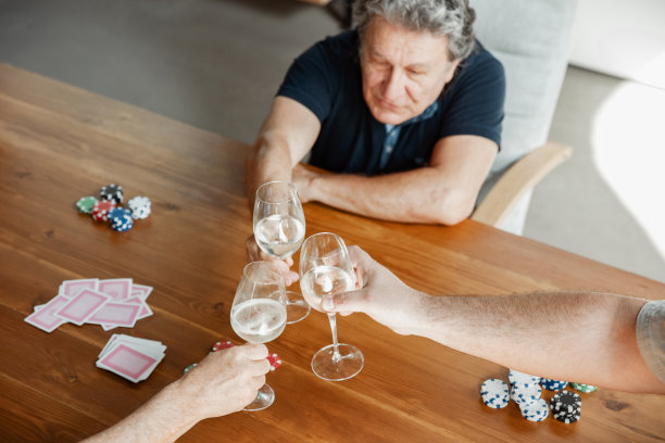 亲密的一群快乐成熟的朋友打牌喝酒图片下载