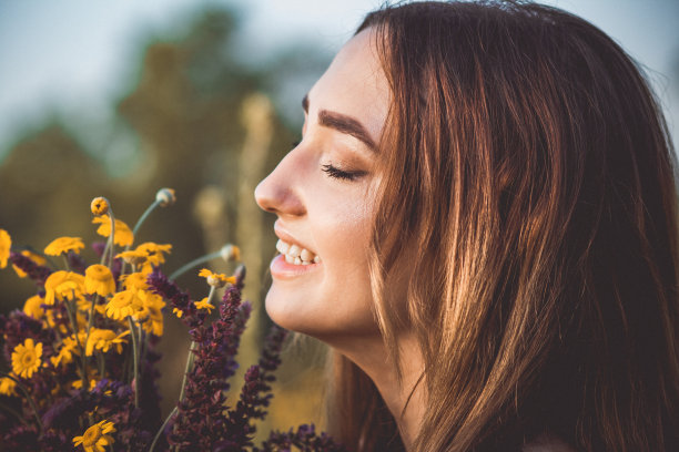 美丽的女孩与野花在草地上，年轻的女人长头发穿着衣服走在自然，夏天温柔的照片在村庄图片下载