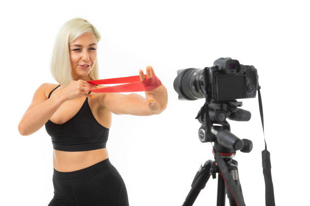 运动白种女孩做运动与橡皮筋扩展在镜头前，肖像孤立在白色背景图片下载