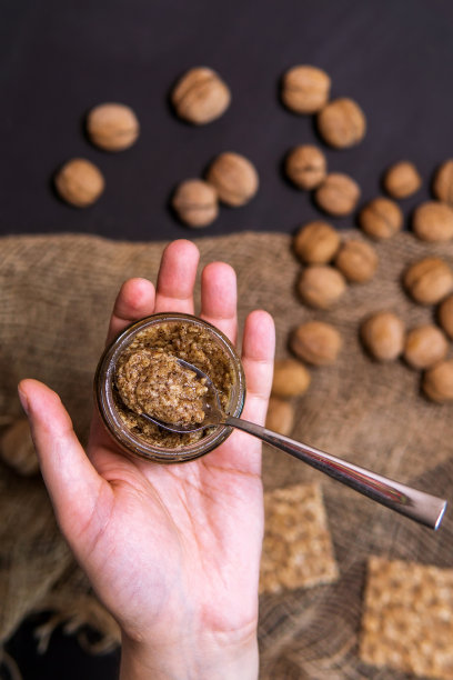 生的有机核桃黄油和新鲜的坚果。垂直照片选择焦点图片下载