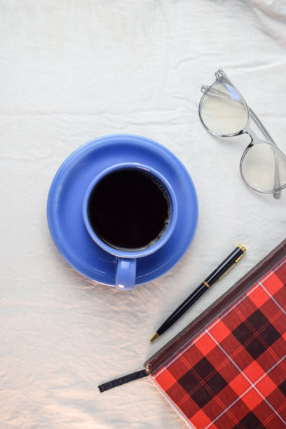 一杯咖啡，笔，书和眼镜在白色的背景。放松咖啡概念图片下载