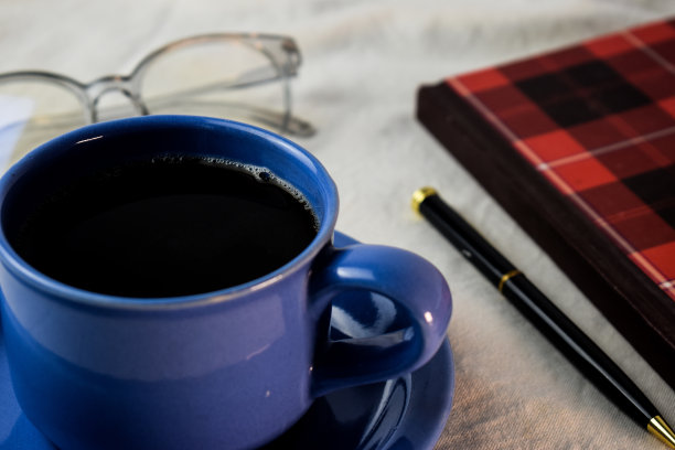 一杯咖啡，笔，书和眼镜在白色的背景。放松咖啡概念图片下载