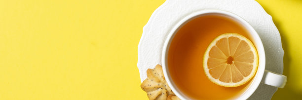柠檬茶，白色杯子，黄色背景。带有文本空间的俯视图。网站的横幅图片下载