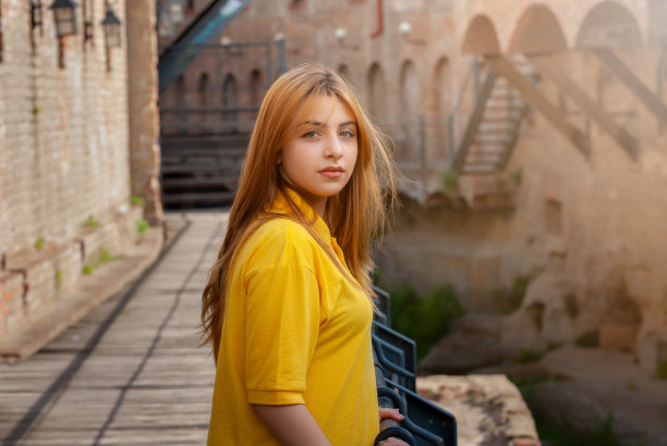 穿着黄色衬衫的美丽少女在老城公园图片下载