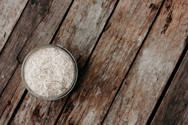 木桌上的玻璃罐里装着大米。意大利调味饭的配料。俯视图，文本空间。图片下载