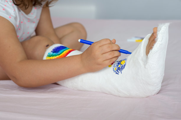 儿童腿部骨折，青少年在接受急救后于骨科病房休息，白色病床上打着石膏的婴儿腿部特写图片下载