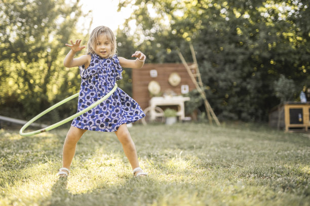 快乐的小女孩穿着裙子在户外玩呼啦圈图片下载
