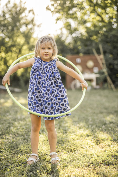 快乐的小女孩穿着裙子在户外玩呼啦圈图片下载