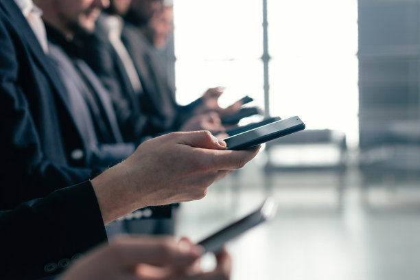 关闭了。一群拿着智能手机的年轻商人的图片图片下载