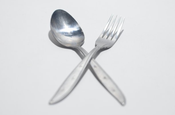 银色的叉子坐在银色的勺子在白色孤立的背景图片下载