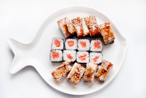 寿司卷是用鳗鱼、鳄梨、黄瓜、鲑鱼等做成的鱼盘。前视图。图片下载