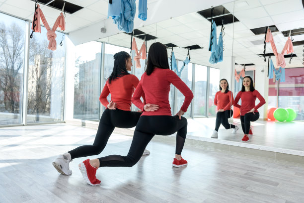 私人教练协助女性在明亮的健身房为运动健身热身图片下载