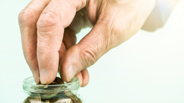 老人手从小玻璃容器中取出金币图片下载