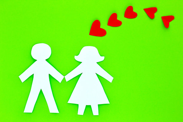 剪影，在明亮的绿色背景下从纸上剪下的情侣形象。情人节的概念，婚礼，爱情，真实的感觉，传统的异性情侣。副本的空间。图片下载