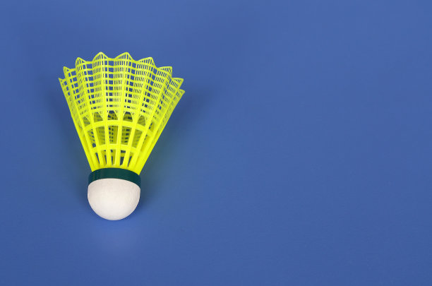 黄色羽毛球在蓝色背景与复制空间图片下载
