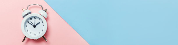 简单简约的设计，双铃响，经典闹钟，隔离在蓝色粉色的柔和背景上。休息小时，生活时间，早安，晚安，醒来，清醒的概念。平躺俯视图拷贝空间，横幅图片下载