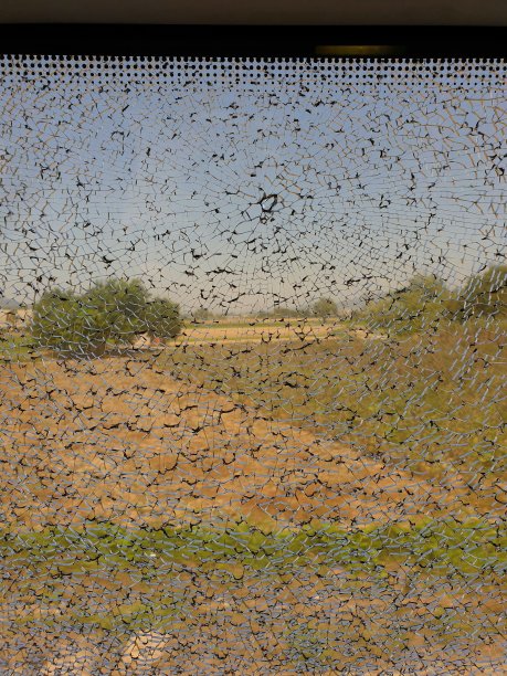 透过破碎的玻璃看风景的细节，窗户上被打碎的裂缝。破坏，爆炸，打击，破坏公物，流氓行为。图片下载