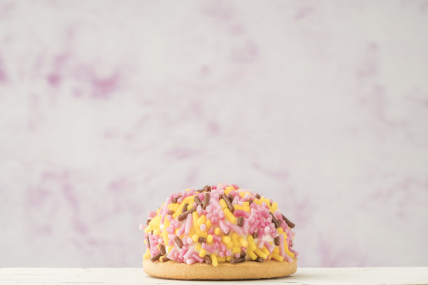 小奶酪蛋糕装饰彩色糖果洒在粉红色的复制空间图片下载
