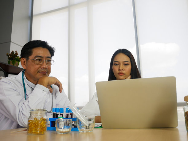 肖像快乐医生团队讨论和持有冠状病毒疫苗在诊所或病房使用。图片下载