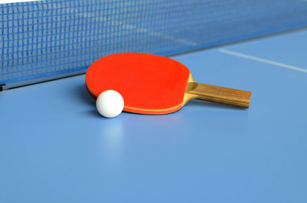 乒乓球桌上有球拍和球图片下载