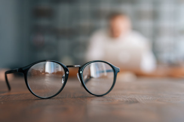 现代办公室的木桌上放着时尚的眼镜图片下载