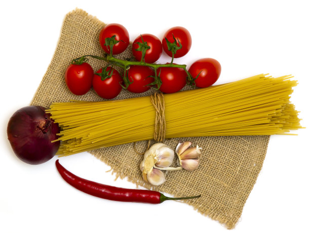 在一个白色的盘子里放意大利面西红柿，洋葱，大蒜和胡椒。图片下载