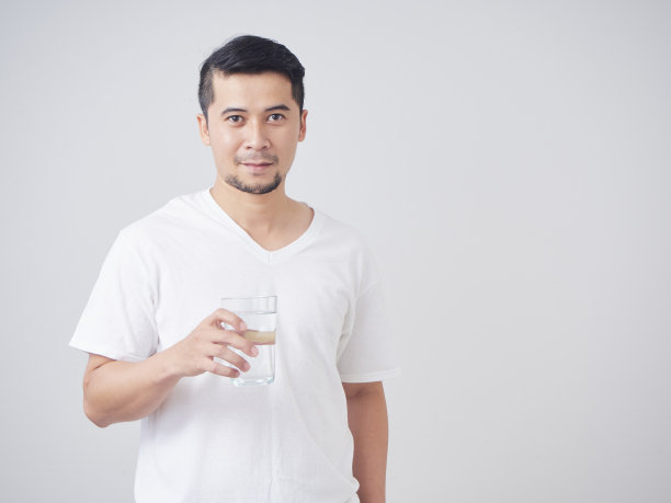 一个年轻人拿着一杯饮用水，背景是白色的图片下载