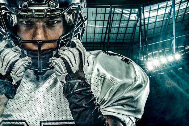 美国足球运动员。戴着头盔带球的运动员在体育场比赛。体育墙纸。团队运动。图片下载