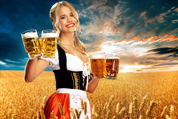 年轻性感的啤酒节女服务员，穿着传统的巴伐利亚或德国宽腰宽裙，在室外端上两个大啤酒杯。图片下载