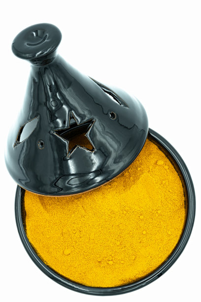 黑色工匠tajine与黄色姜黄从上面看，理想的典型印度美食照片图片下载