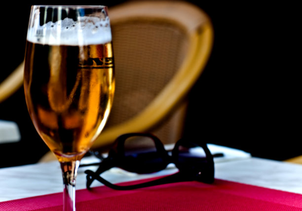夏天喝杯啤酒。太阳镜在桌面上。图片下载