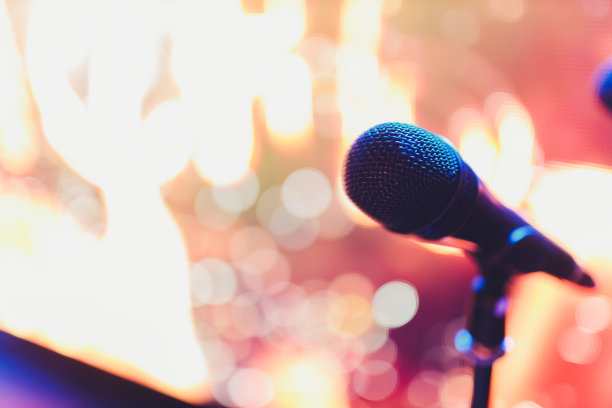 近距离的麦克风在观众席舞台上模糊的背景。图片下载