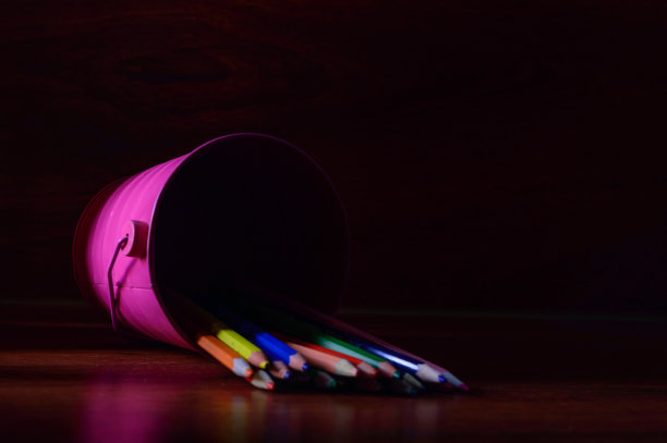 不同颜色的铅笔在一个粉红色的金属桶里。图片下载