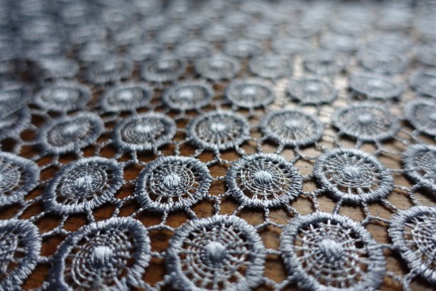 近距离拍摄的银灰色钩针花边织物上的木材图片下载