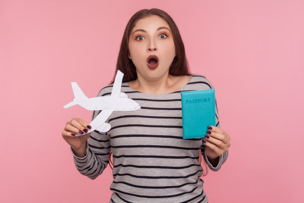 哇，我要去旅行了!肖像的美丽的年轻女子持有护照和纸飞机图片下载