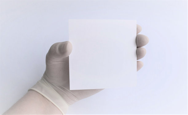 医用模板上的文字在医生手中，戴着防护手套，白色中性背景图片下载