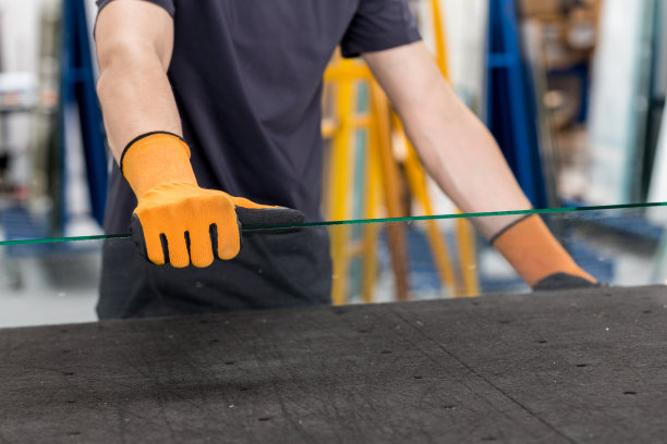 玻璃厂，玻璃工人举起桌子上的玻璃图片下载