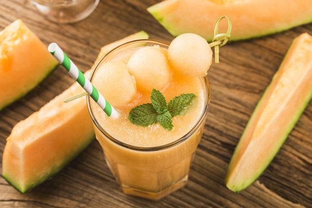 桌上放着一杯薄荷甜瓜汁。哈密瓜图片下载