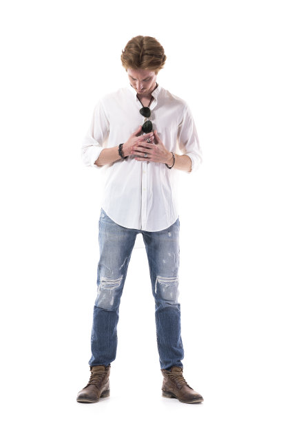 穿着白衬衫和牛仔裤的严肃的年轻人低头看着，手牵着手，穿着衣服图片下载