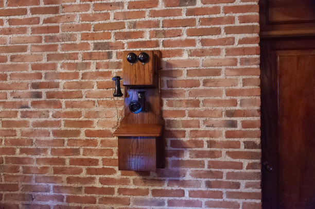 1917年在砖墙上使用老式电池的木墙电话。图片下载