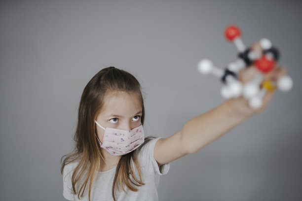 戴着口罩的女孩拿着分子模型图片下载