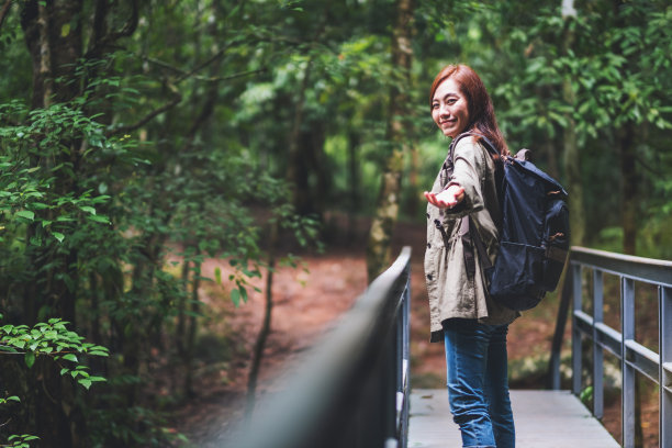 一个年轻的女人牵着她的手走进了树林图片下载
